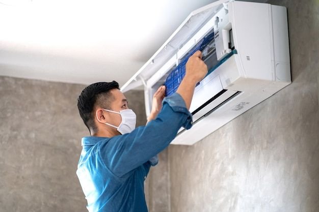 Technician man repairing ,cleaning and maintenance air conditioner Premium Photo